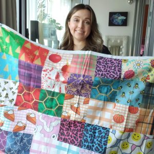 a woman holding a set of fabric swatches from spoonflower