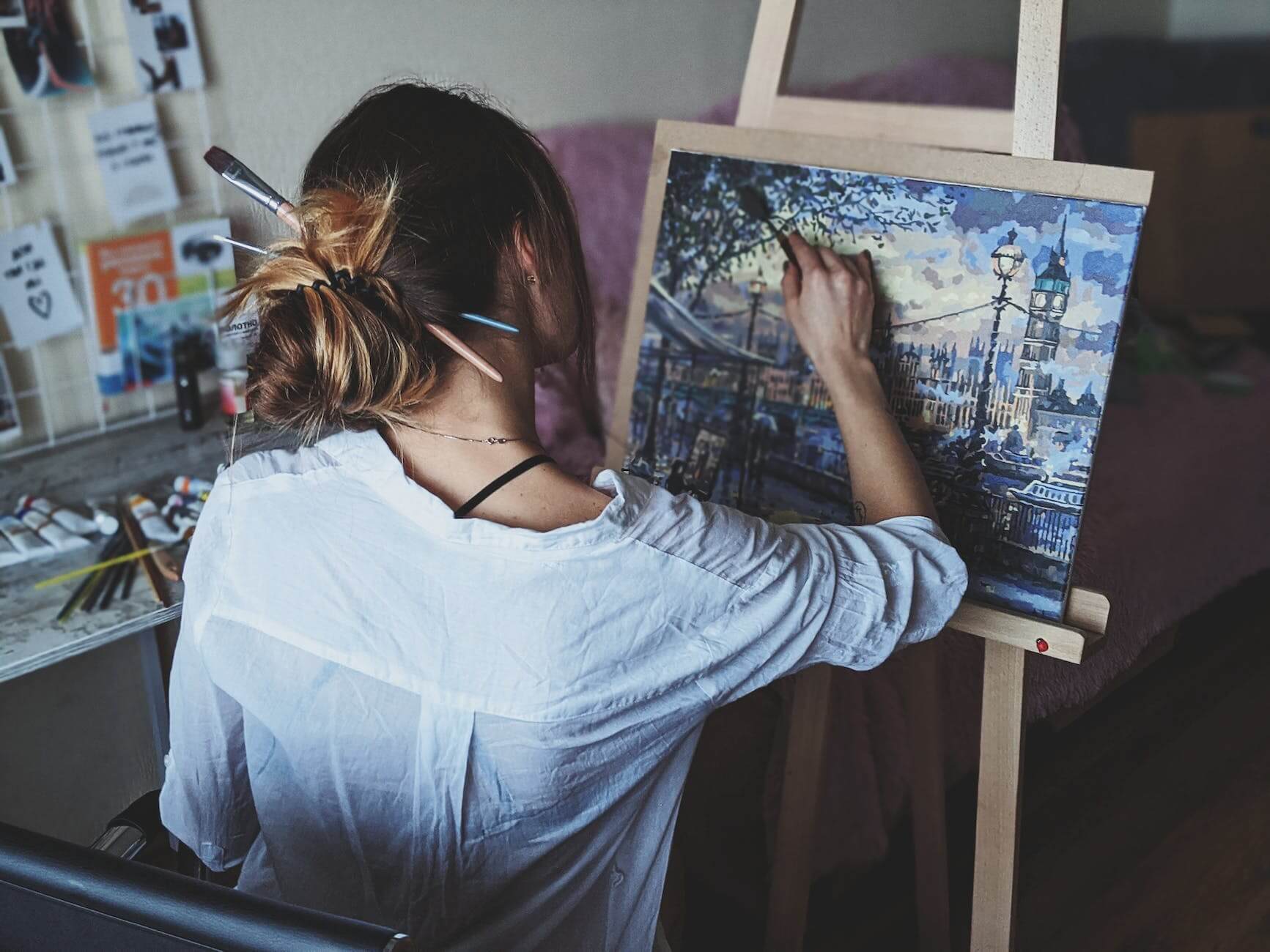 an artist painting a cityscape